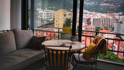 a living room with a couch and a table in front of a window at Sea view Studio Terminal in Budva