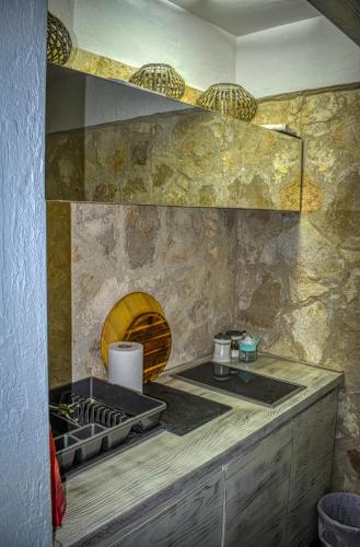 a kitchen with a stove and a stone wall at Sea view Studio Terminal in Budva