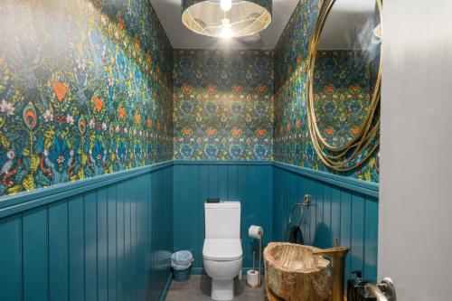 a bathroom with blue walls and a toilet and a mirror at Towan House in Newquay