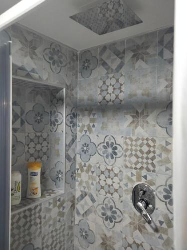 a bathroom with a shower with blue and white tiles at D&A in Boscoreale