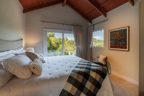 - une chambre avec un grand lit et une fenêtre dans l'établissement Vila Manaca Da Serra, à Canela