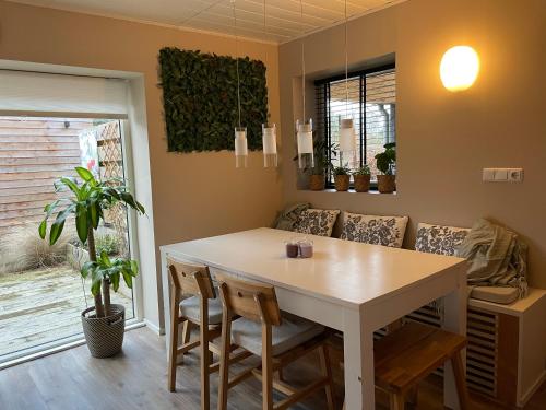 a dining room with a table and a couch at B&B Tulden Farmhouse in Giethoorn