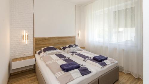 ein Schlafzimmer mit 2 Betten und blauen Kissen darauf in der Unterkunft Kendosz Apartman in Gyenesdiás