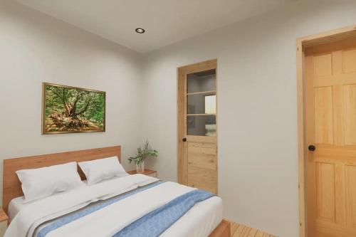 een witte slaapkamer met een bed en een raam bij Squam waterfront 2 bed 2bath (Suite 8) in Holderness