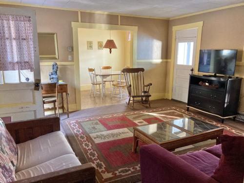 a living room with a couch and a table at Moose Manor- Squam Waterfront in Holderness