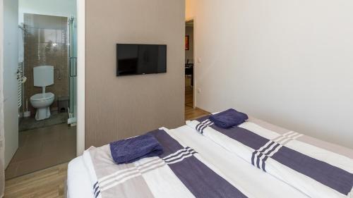 ein Schlafzimmer mit einem Bett mit zwei Kissen darauf in der Unterkunft Kendosz Apartman in Gyenesdiás