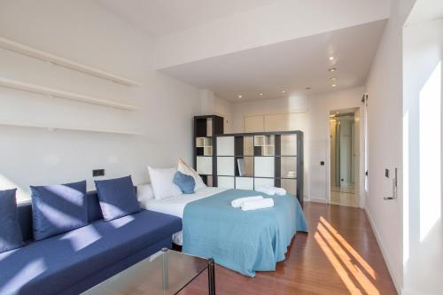 - une chambre avec un lit bleu et un canapé bleu dans l'établissement Villa Cela, à El Masnou