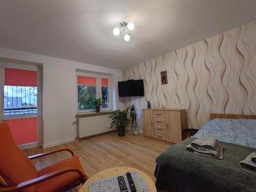 a bedroom with a bed and a tv on the wall at Emilka 2 in Suwałki