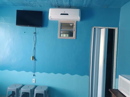 サリノポリスにあるApartamentos no Farol Velhoの青い壁の客室で、エアコンが備わります。