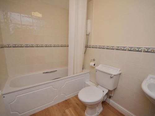 a bathroom with a toilet and a tub and a sink at 3 Bed in Wembury COMBV in Wembury