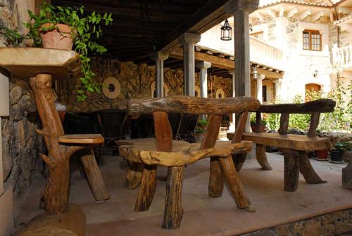 a group of wooden benches sitting on a patio at Hotel Rural El Cañón del Duratón in Sepúlveda