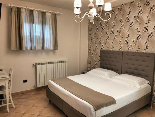 a bedroom with a bed and a chandelier at Bed & Breakfast De Nittis in Barletta
