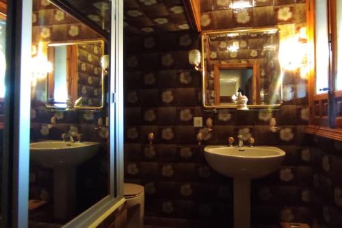 a bathroom with two sinks and a mirror at La Casona de Toledo in Gerindote