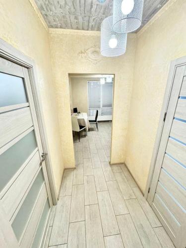 un pasillo con una habitación con una mesa y un techo en Italy style apartament, en Chişinău