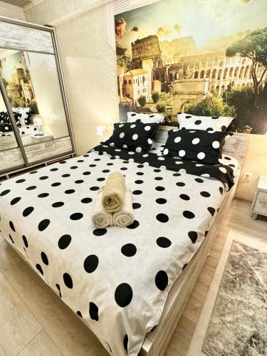 Cama grande con sábanas y almohadas blancas y negras en Italy style apartament, en Chişinău