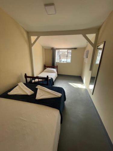 a room with two beds and a window at Hospedagem ao lado do centro histórico in Paraty