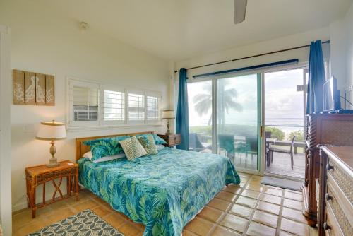 1 dormitorio con 1 cama y puerta corredera de cristal en Waianae Beach House with Direct Coast Access and Views en Waianae