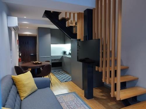 ein Wohnzimmer mit einem blauen Sofa und einem TV in der Unterkunft Almada 505 City Center Duplex in Porto