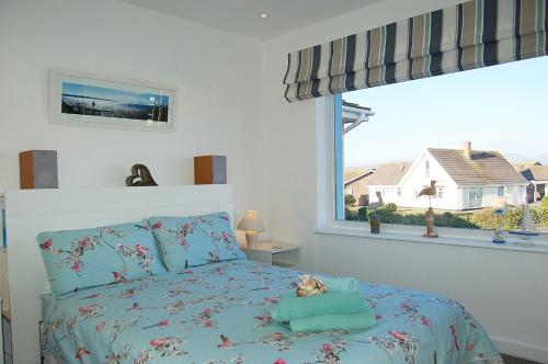 a bedroom with a bed and a large window at Ann's Beach House in Tywyn in Tywyn