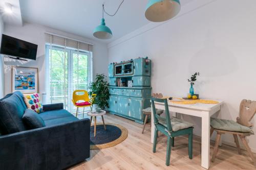 a living room with a blue couch and a table at Apartament Bulwary Łyna przy Starym Mieście in Olsztyn