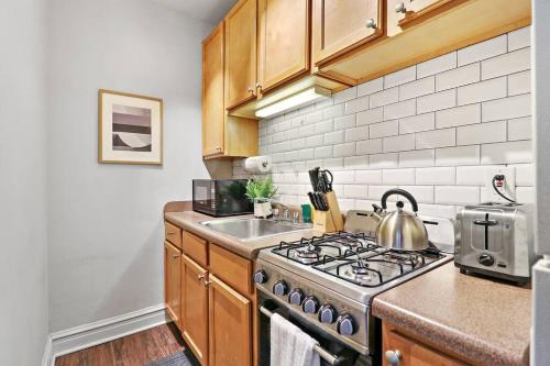a kitchen with a stove and a sink at City Charm Studio Apt in Chicago - Kenwood 205 in Chicago