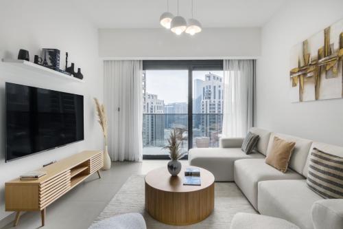 a living room with a couch and a large window at Downtown Dubai- 2BR Apartment in ACT Towers in Dubai