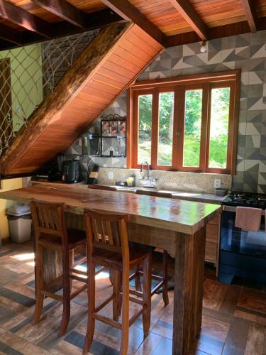 a kitchen with a large wooden table and chairs at Casa Araucária 2 in Visconde De Maua