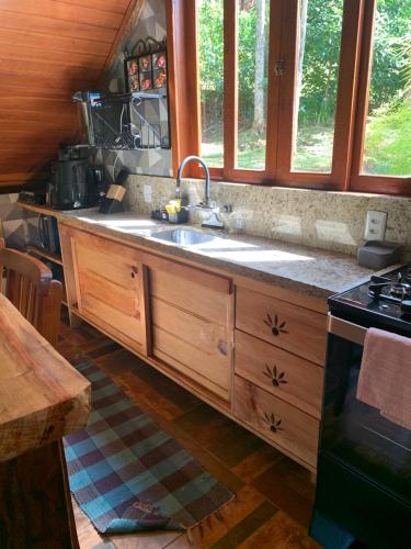 a kitchen with a sink and a stove at Casa Araucária 2 in Visconde De Maua