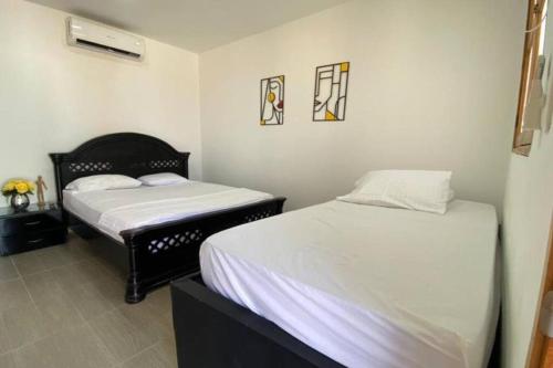 a room with two beds in a room at Brisas de barú in Ararca