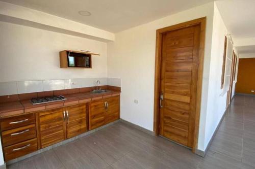 a kitchen with wooden cabinets and a wooden door at Brisas de barú in Ararca