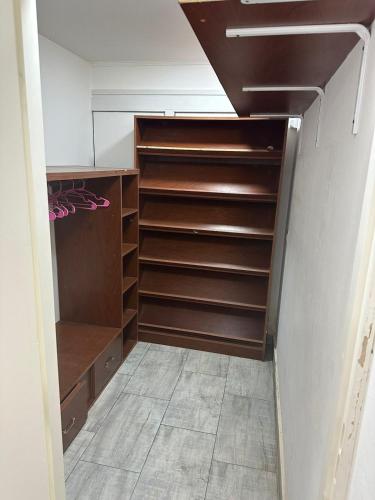 Un vestidor con estantes de madera en Monoambiente Serena Depto, en Mar del Plata