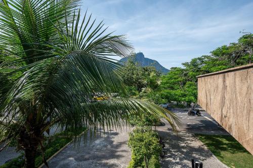 una palmera junto a una carretera con una montaña en 2 quartos em Ipanema com vista para Lagoa e Cristo, en Río de Janeiro