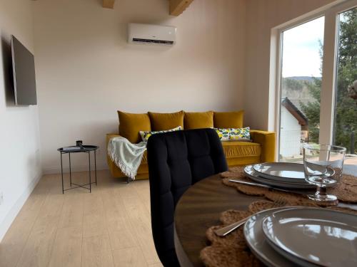 a living room with a table and a yellow couch at Słoneczny Stok in Małastów