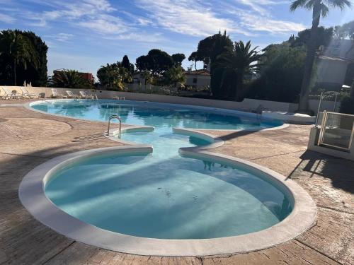 une grande piscine d'eau bleue dans l'établissement À 5 minutes de Monaco appartement vue mer haut de gamme, à Roquebrune-Cap-Martin