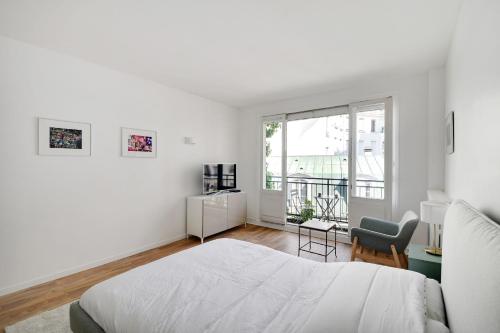 une chambre blanche avec un lit et une chaise dans l'établissement Bright Studio for 2 - Champs-Elysées, à Paris