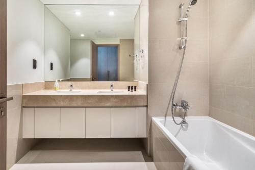 Downtown Dubai- 2BR Apartment in ACT Towers في دبي: حمام مع حوض وحوض ومرآة