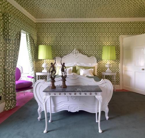 a bedroom with a white bed and a table at Carrington House in Snettisham