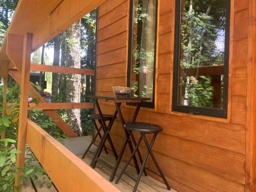 een kleine tafel op de veranda van een houten huis bij cabaña del bosque in Villarrica