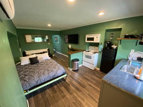 um quarto com uma cama e uma cozinha com paredes verdes em Lexington Getaway em Lexington
