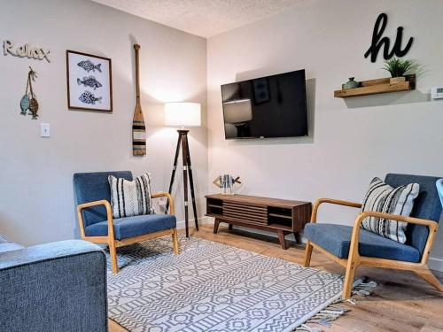 a living room with two chairs and a tv at Timber Point Villa # 7 Bernie's Bungalo in Branson