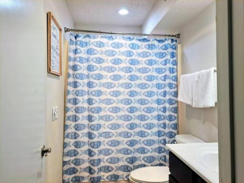 a bathroom with a blue and white shower curtain at Timber Point Villa # 7 Bernie's Bungalo in Branson