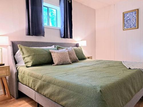 a bedroom with a large bed with green sheets at Timber Point Villa # 7 Bernie's Bungalo in Branson