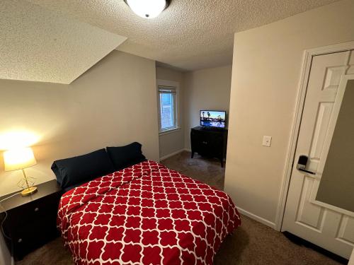 a bedroom with a red bed and a television at Lyndale Oasis in Minneapolis