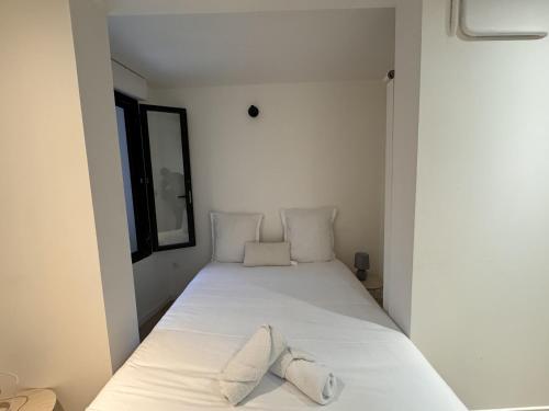 a bedroom with a white bed with two pillows at Le Repère des Pilotes - Gare - 11p - Rêve au Mans in Écommoy