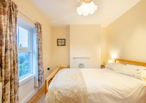 a bedroom with a bed and a window at Old Fishermans Cottage - East Runton in West Runton