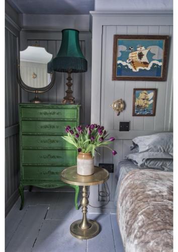 a bedroom with a green dresser and a green lamp at House in Hastings in Hastings
