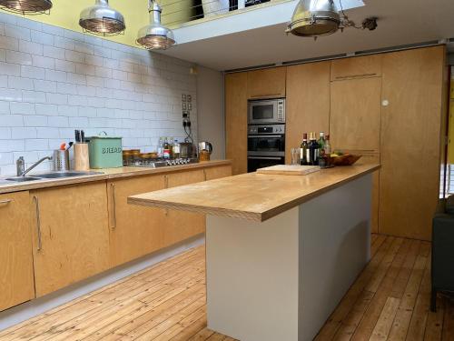 a large kitchen with wooden cabinets and a counter top at Victoria Park Apartment in London