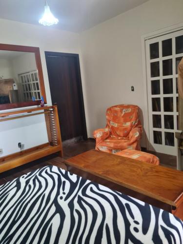 uma sala de estar com um tapete de estampa de zebra e uma cadeira em Suíte Temporada Verão em Torres