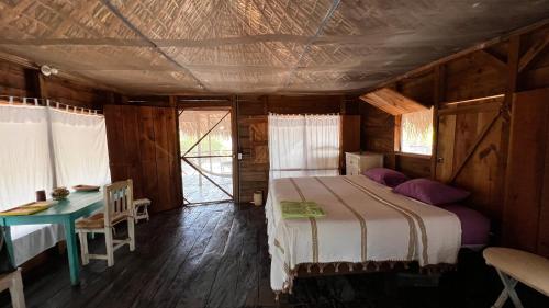 a bedroom with a bed and a table in a room at Cabañas Casa de Agua in Boca del cielo