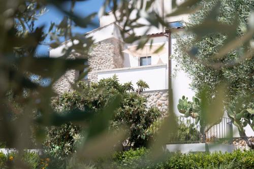 a white building with trees in front of it at Oikos in Terre di Zaccanello in Racalmuto